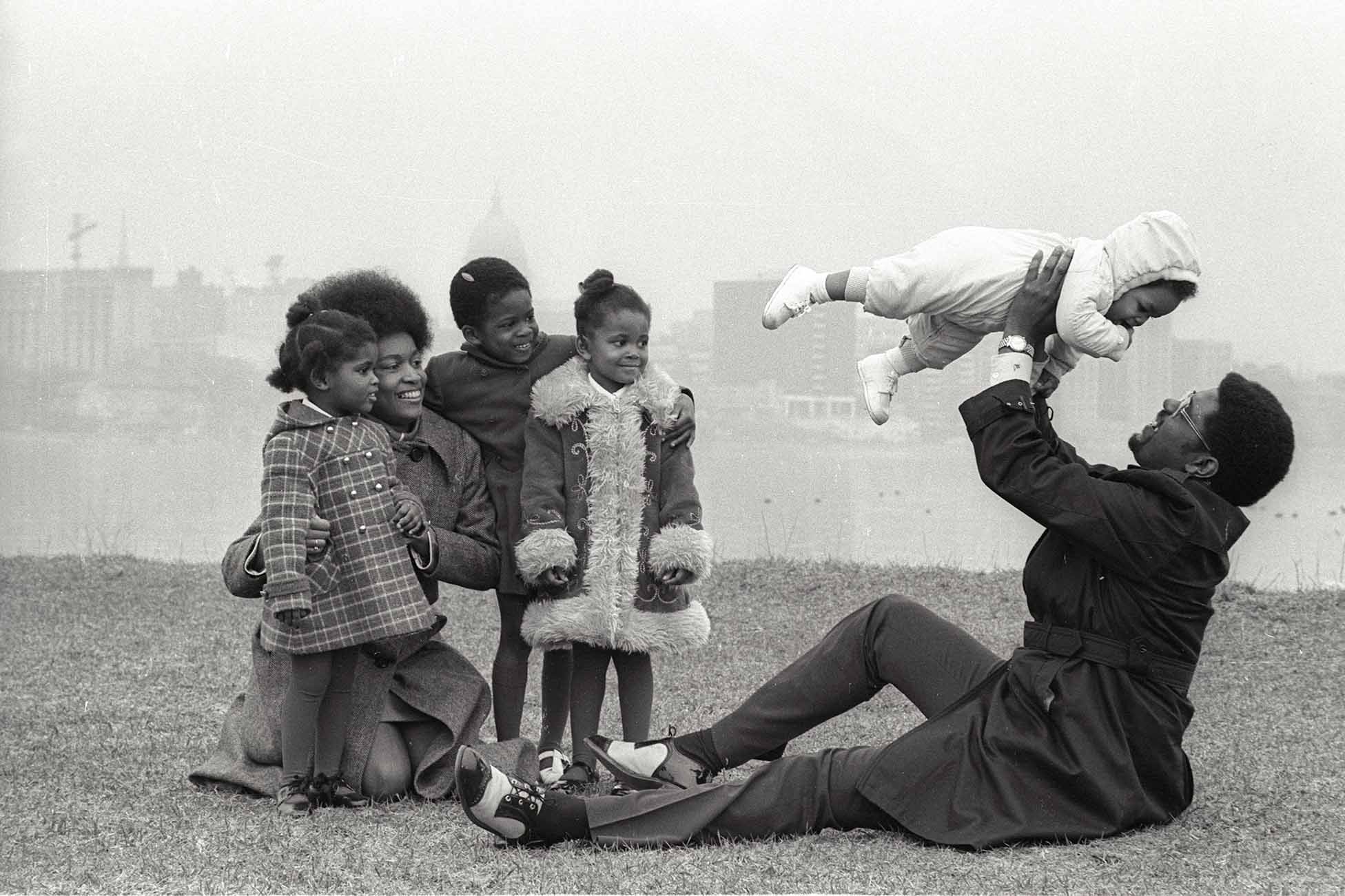 Eugene (Gene) Parks with his wife and children relaxing outdoors. From left to right are Kendra Parks, Marilyn Park, Wendy Parks, Stacey Parks, Reggie Parks (the baby) and Eugene Parks. 