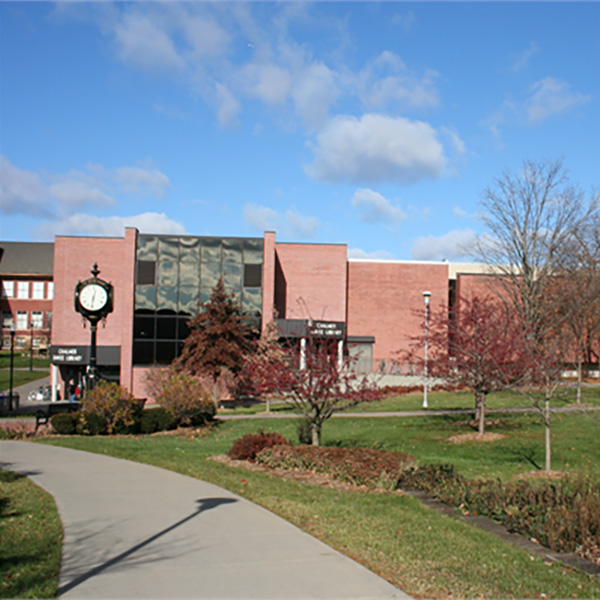 The Chalmer Davee Library building stands past a sidewalk and a clock pole.