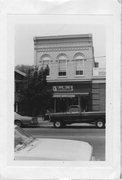 180-184 E MAIN ST, a Romanesque Revival retail building, built in Stoughton, Wisconsin in 1876.