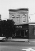 180-184 E MAIN ST, a Romanesque Revival retail building, built in Stoughton, Wisconsin in 1876.