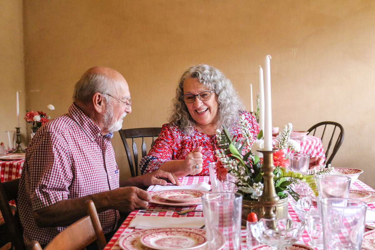 two people at a historic site, sitting at a table set for spring festivities.