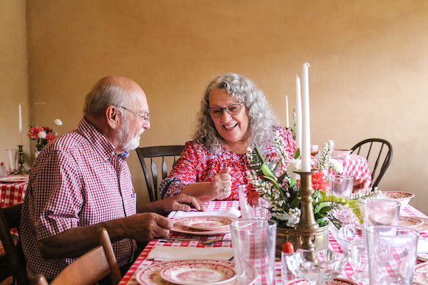 An older couple happily sits at a table at the Pendarvis Historic Site