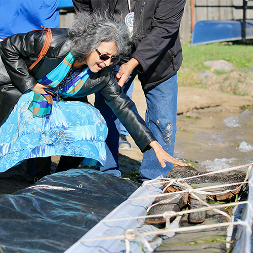 Ho-Chunk woman excitedly touches the canoe of her ancestors.