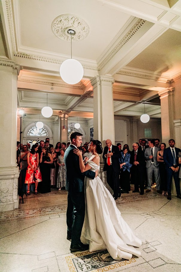 A couple look lovingly into each others arms as they have their first dance together in the lobby