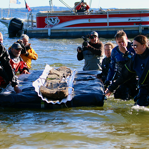 team floats the canoe out of Lake Mendota