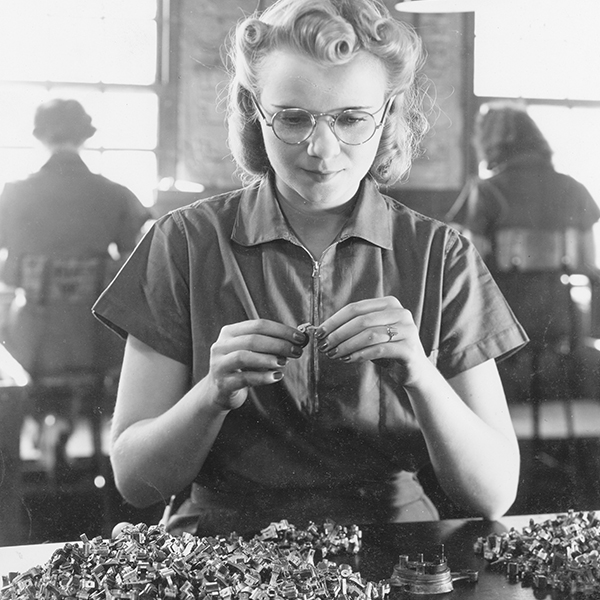 Female worker inspecting small plastic and metal parts at International Harvester's West Pullman Works.
