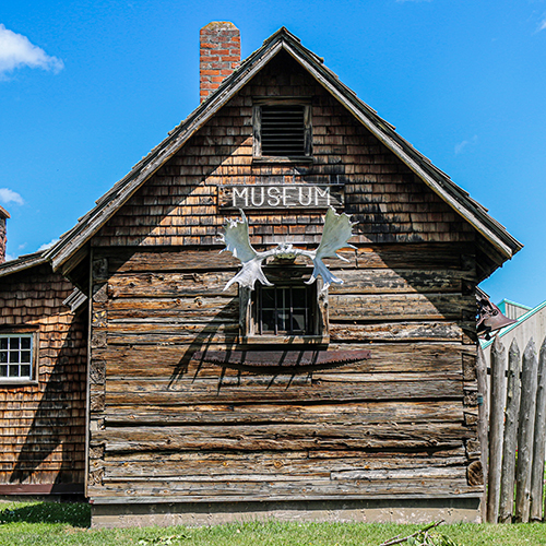 Wood cabin style building with antlers attached. A sign reads Museum