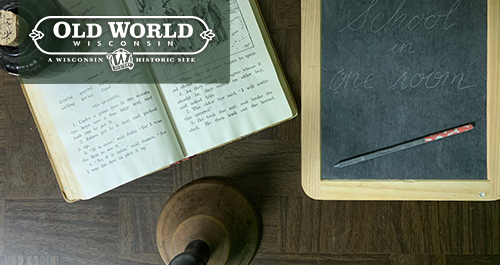 Old World Wisconsin. A desk in a one room school house showcasing a book, a slate, and an ink pot.