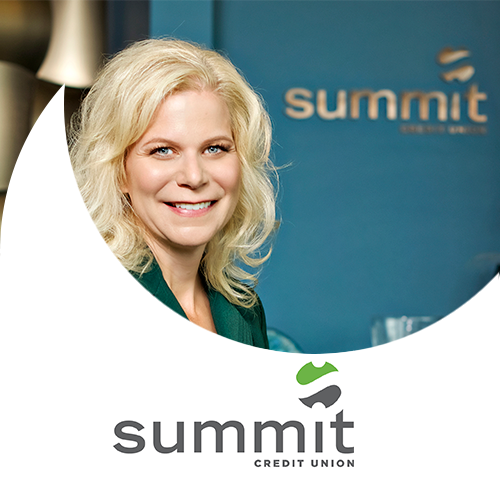 Kim Sponem in a formal portrait at Summit Credit Union. Blonde Hair curled about shoulders, and an emerald green suit.