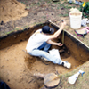 Field archaeologist drawing trench wall. 