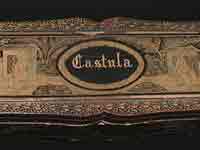 Exterior of Castula fan box, ornately carved with a detailed garden scene.