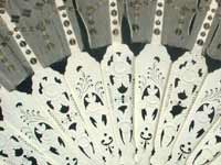 Close up of carved ivory sticks on fan.