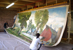 Conservators work on restoring a mural.